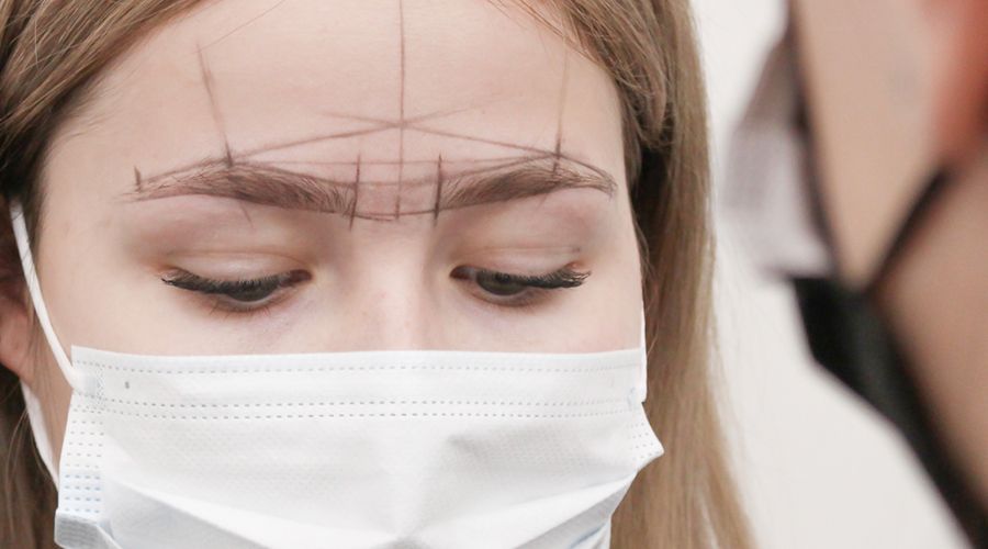 woman with face mask and brow marking lines on face