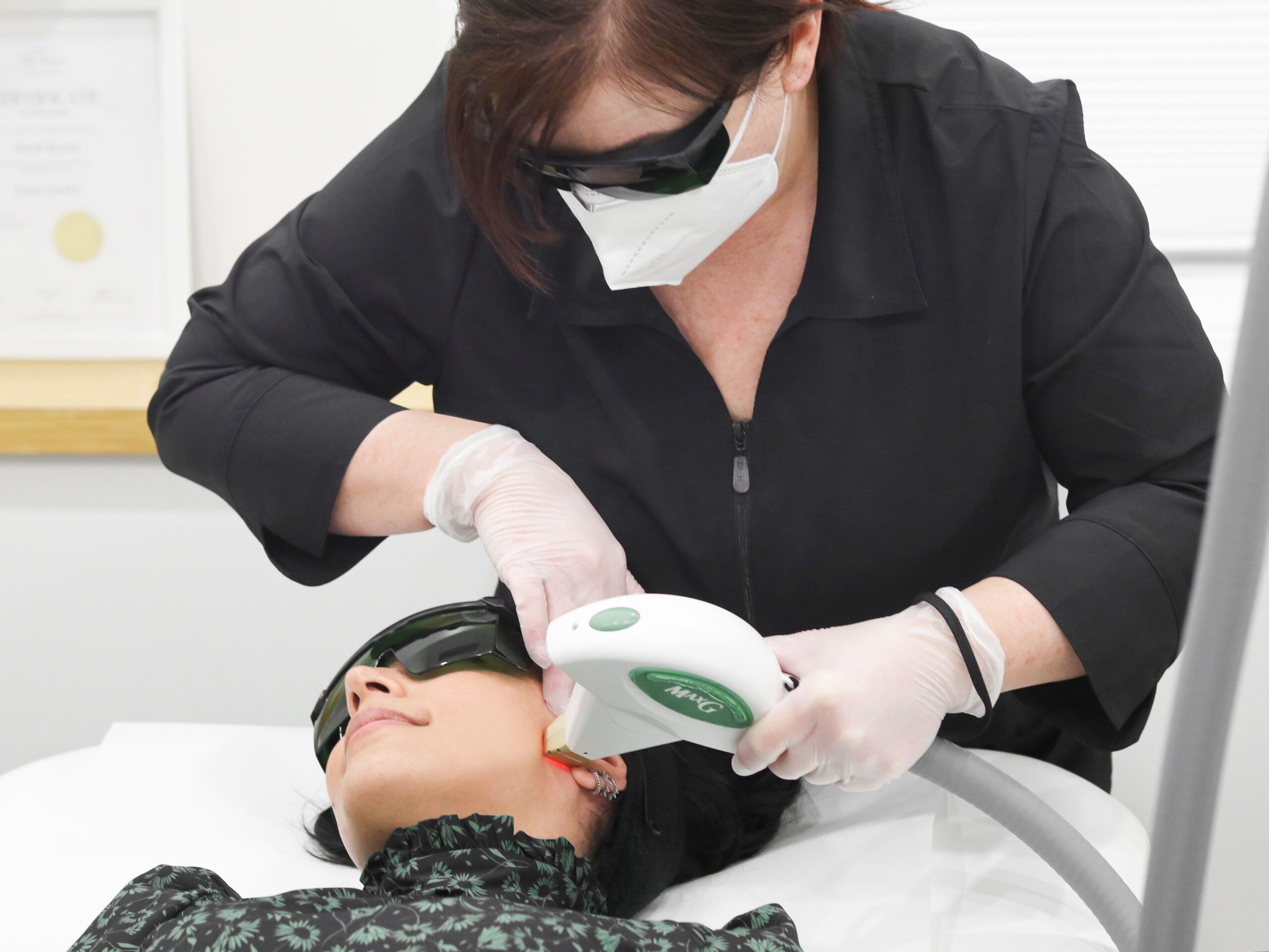Esthetician doing a photofacial laser three for me service on a client
