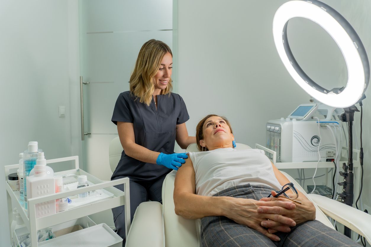 Esthetician explaining skincare services during a relaxing spa treatment.