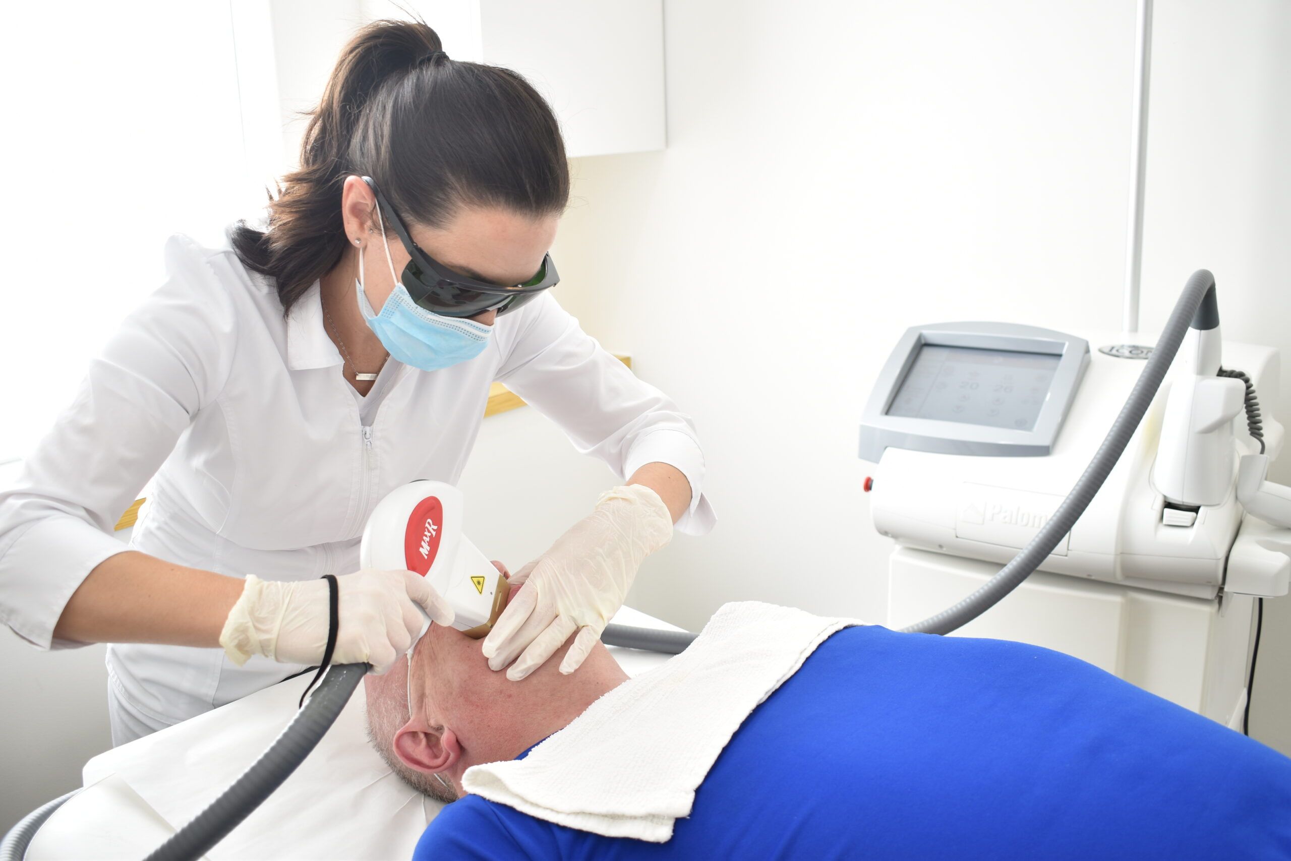 "man getting a laser hair removal service on his face"