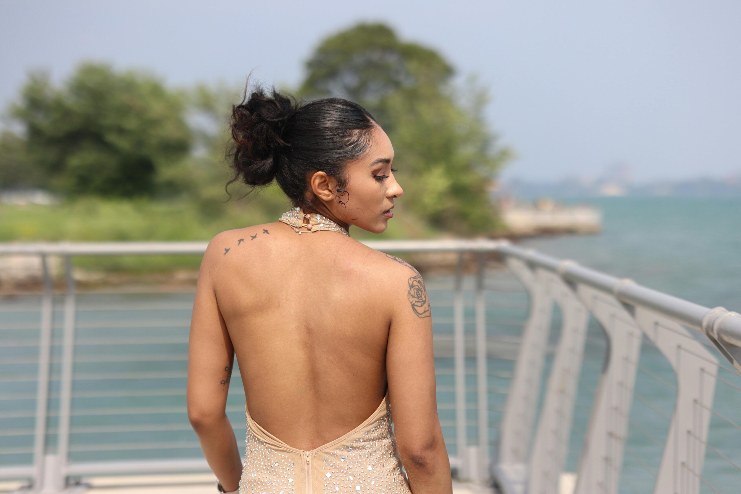 "woman standing in a backless dress"