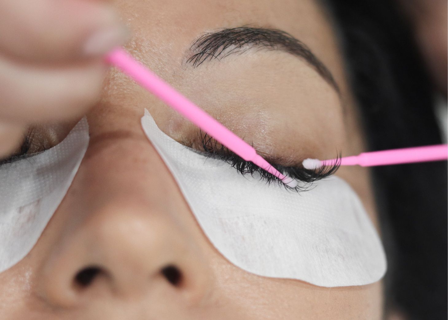 Model receiving lash removal service at Wrapture Beauty Academy