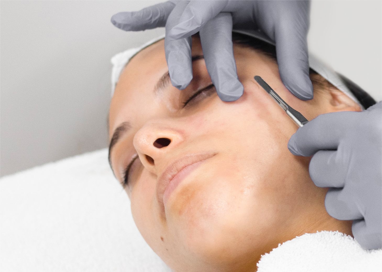 Model receiving dermaplaning vellus hair removal treatment at Wrapture Beauty Academy