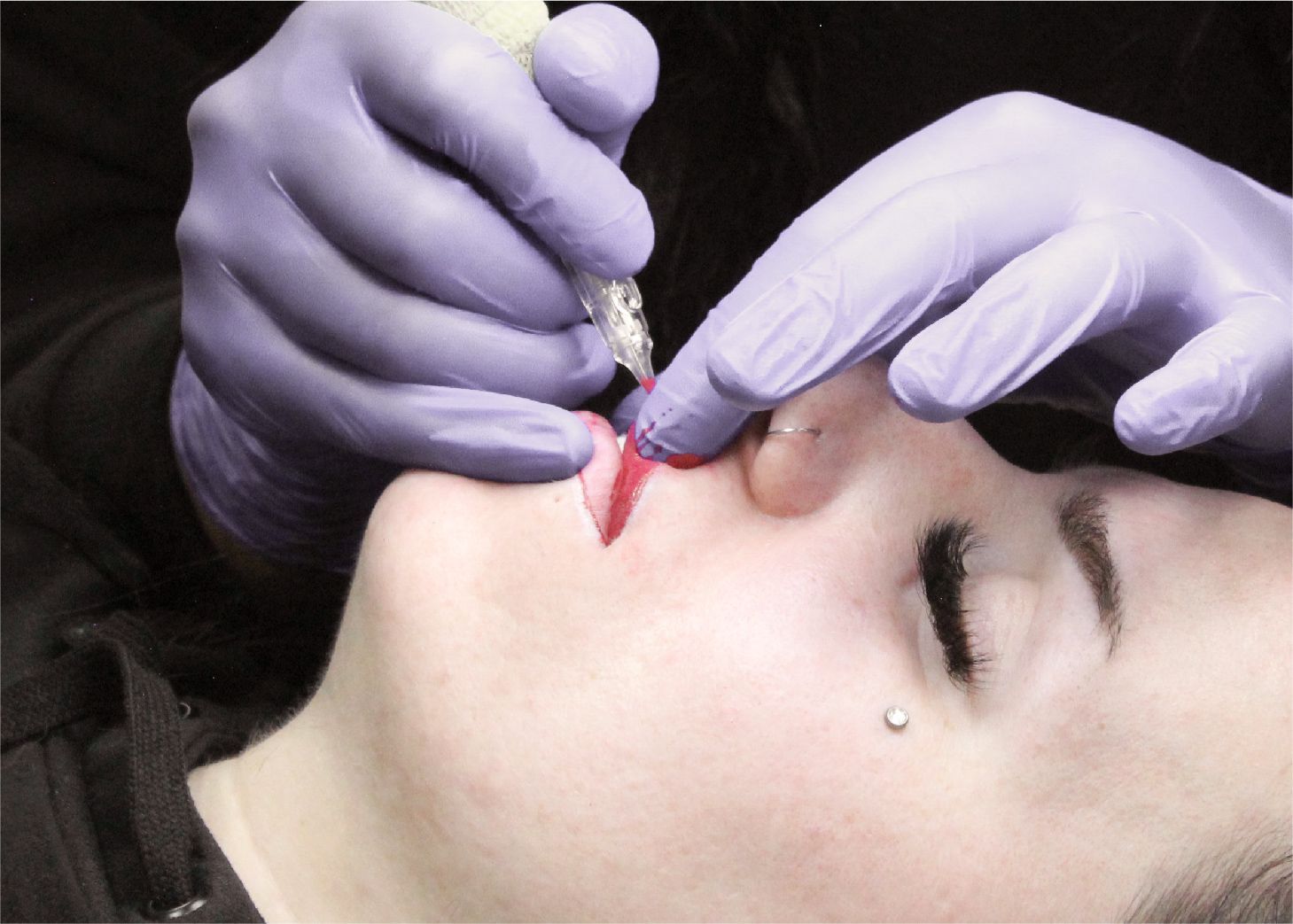 Client receiving lip blushing treatment