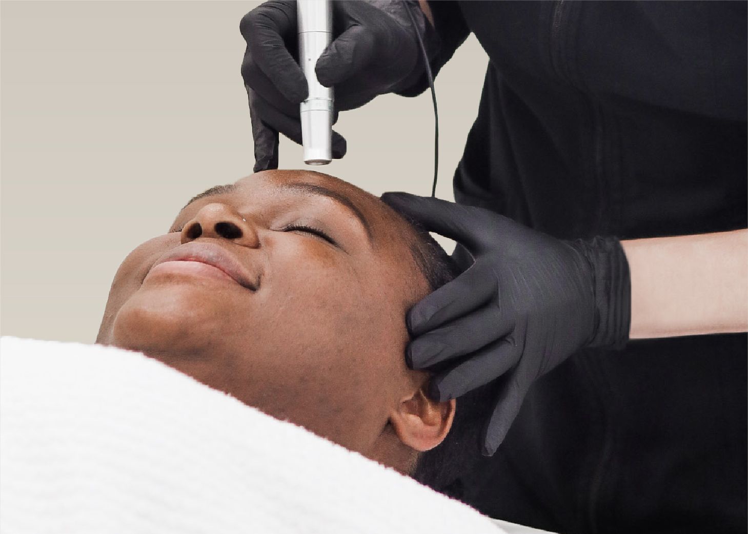 Model receiving microneedling face treatment at Wrapture Beauty Academy