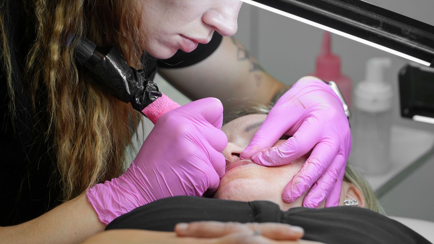 Micropigmentation artist performing lip blush treatment on client