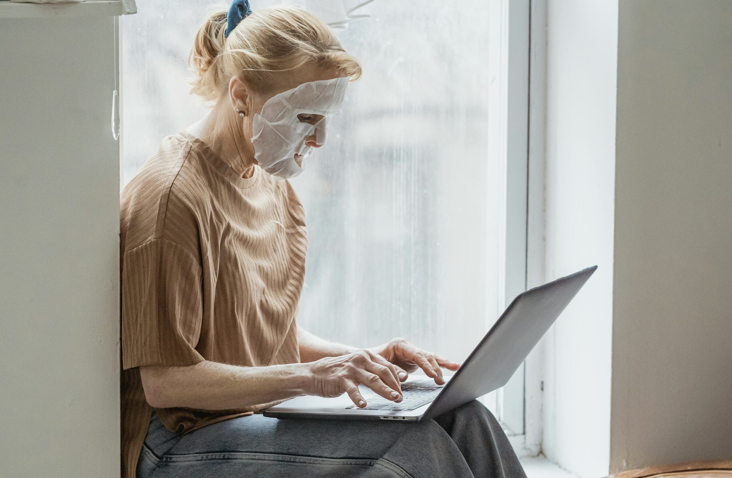 “Person mastering dermaplaning with our comprehensive online course in Canada while doing a facemask.”