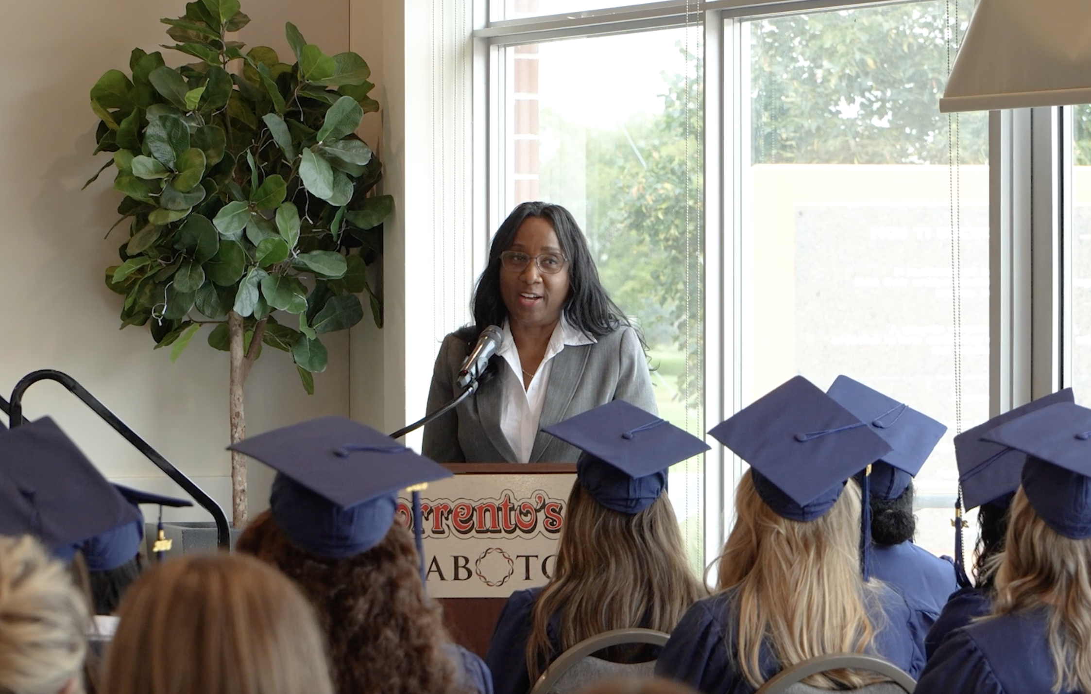 The founder of Wrapture Beauty Academy speaking at the podioum