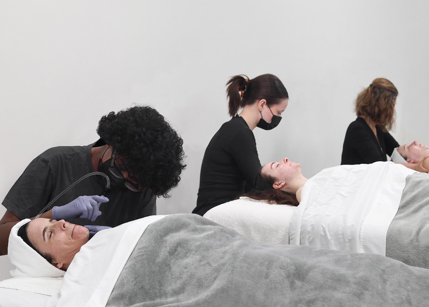 Wrapture Beauty Academy students performing facial services on clients