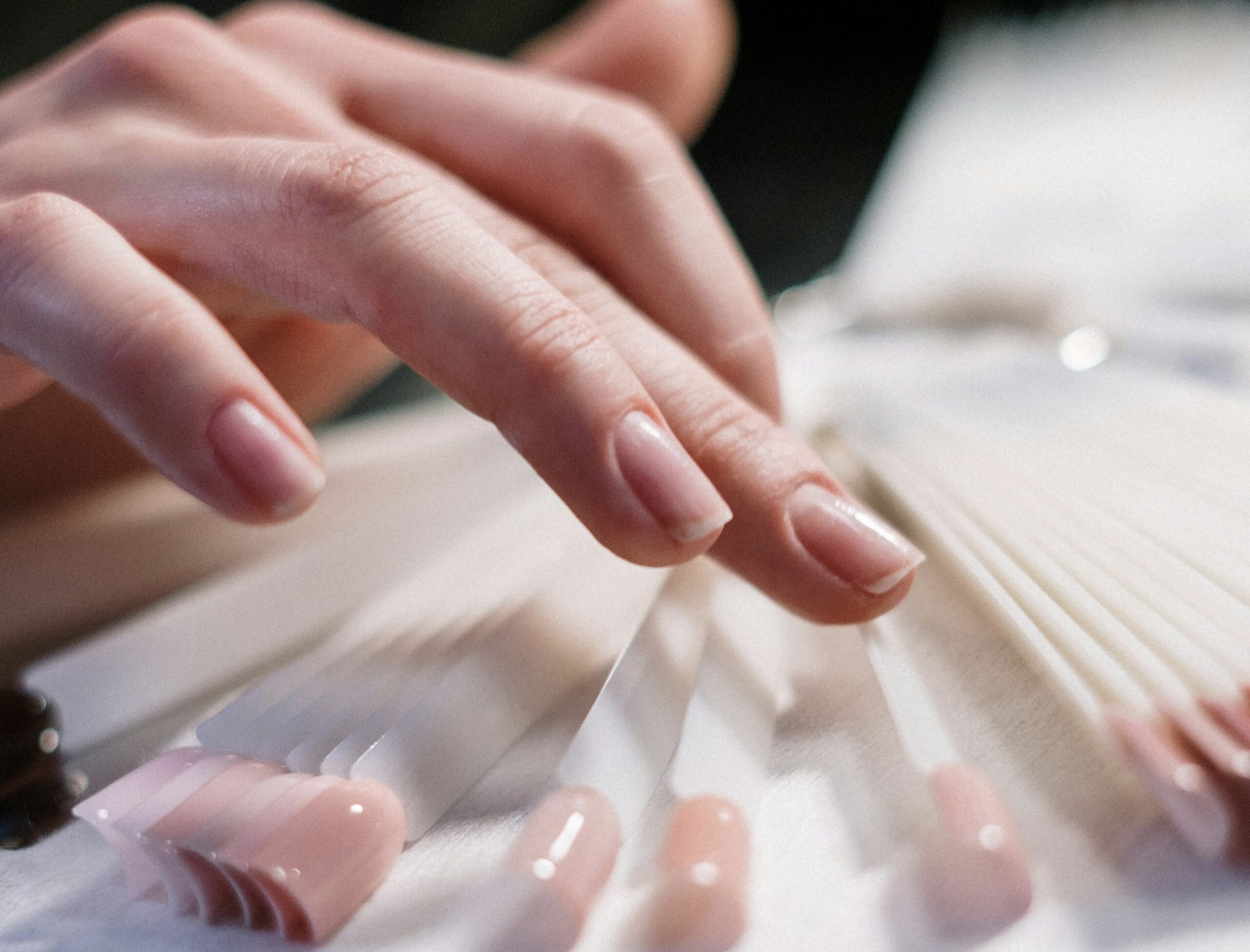 A hand before a manicure picking out a colour from a swatch during esthetician courses in winnipeg