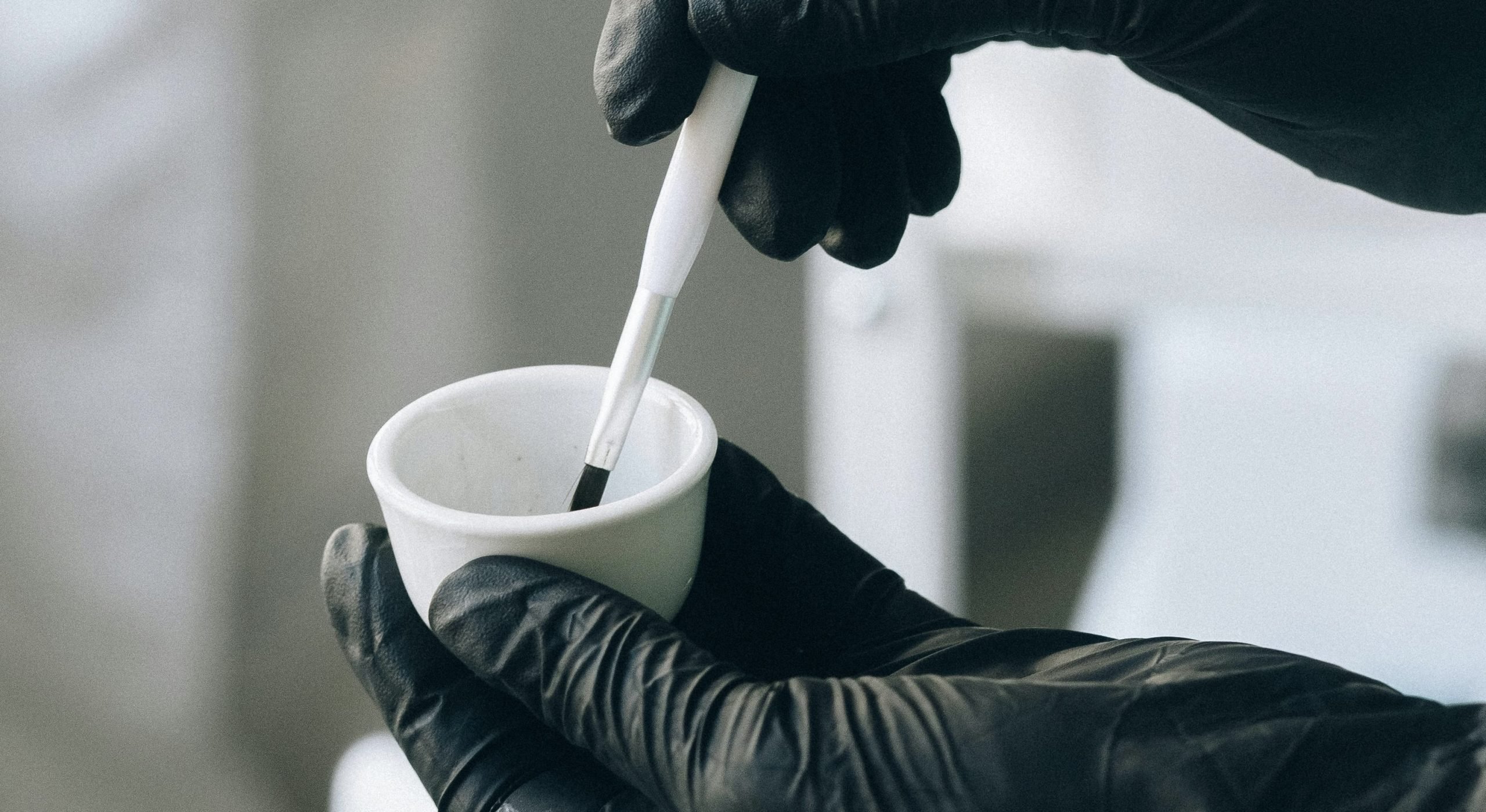 Online lash lift and tint course participant holding a tint brush and tint